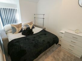 A bedroom with a bed and bedside table at Rhows in Niwbwrch (Newborough)