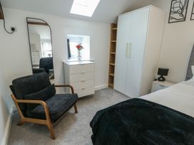 A bedroom with a bed, dresser, and a mirror at Rhows in Niwbwrch (Newborough)