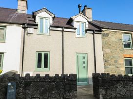 A house with green door and windows at Hen Siop Niwbwrch (newborough)