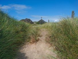 A path through grass leading to a cross on a hill at Hen Siop in Niwbwrch (newborough)