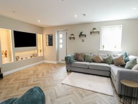 A living room with a sofa and television at Hen Siop in Niwbwrch (Newborough)