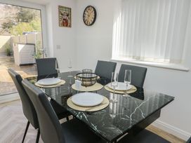 A dining room with a table set for six at Hen Siop in Niwbwrch (Newborough)