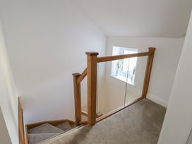 A stairwell with a staircase and a window at Hen Siop in Niwbwrch (Newborough)