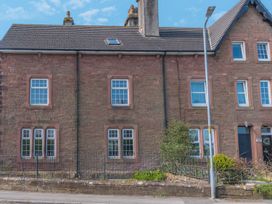 A stone house with multiple windows and a fenced garden in front at 1 Cleator Gate in Cleator