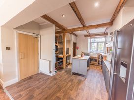 A kitchen with wooden beams a central island wooden cabinets and a large window at 1 Cleator Gate in Cleator