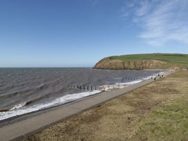 A coastal path beside the sea with a grassy cliff in the background at 1 Cleator Gate in Cleator