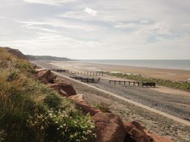 A coastal landscape with a rocky shoreline grassy area and sandy beach at 1 Cleator Gate in Cleator
