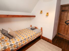 A bedroom with a bed and shelf at 1 Cleator Gate in Cleator