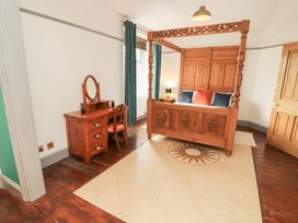 A bedroom with a wooden bed and vanity at 1 Cleator Gate in Cleator