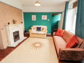 A living room with a fireplace and two sofas at 1 Cleator Gate in Cleator