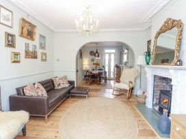 A living room with a sofa and a dining area at 18 Pakefield Road in Lowestoft