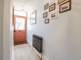 A hallway with a door and photographs on the wall at 18 Pakefield Road Lowestoft