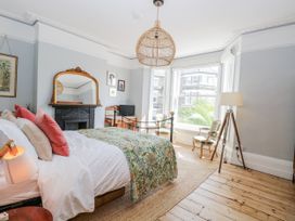A bedroom with a bed and chairs at 18 Pakefield Road Lowestoft