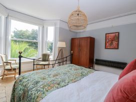 A bedroom with a bed, wardrobe, and lamp at 18 Pakefield Road in Lowestoft