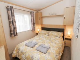 A bedroom with a double bed and bedside lamps at Cate’s Cozy Cabin in High Hesket near Lazonby