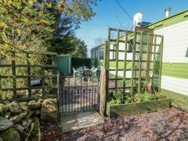 An outdoor area with a gate and table with chairs at Meadow Island Caravan in Penygroes