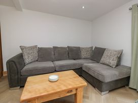 A living room with a sectional sofa and a coffee table at Old Post Office Cottage in Ulverston
