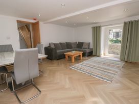 A living room with a sofa and dining area at Old Post Office Cottage in Ulverston