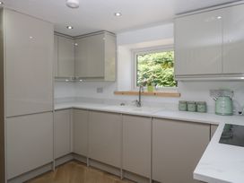 A kitchen with cabinets and sink at Old Post Office Cottage in Ulverston