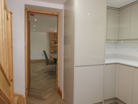A kitchen area with cabinets and a doorway at Old Post Office Cottage in Ulverston