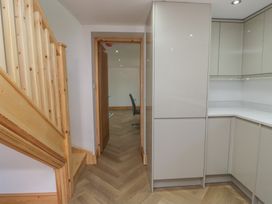 A kitchen with cabinets and a staircase at Old Post Office Cottage in Ulverston