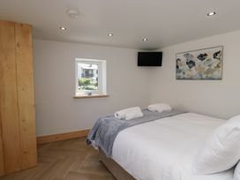A bedroom with a bed and towels at Old Post Office Cottage in Ulverston