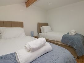 A bedroom with two beds and towels at the Old Post Office Cottage in Ulverston