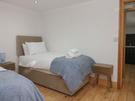 A bedroom with two beds and a nightstand at Old Post Office Cottage in Ulverston