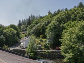 A view of a house and trees near a river at Old Post Office Cottage in Ulverston