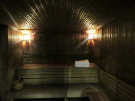 A sauna with wooden benches and a towel at the Old Post Office Cottage in Backbarrow near Newby Bridge