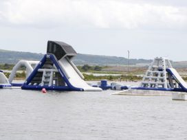 An inflatable water park with slides and obstacles at Old Post Office Cottage Backbarrow near Newby Bridge