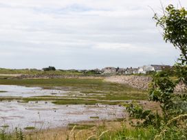 A view of houses along a coastline with marshland at Old Post Office Cottage Backbarrow near Newby Bridge