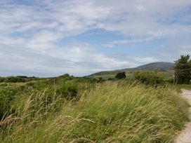 A landscape view featuring grass and mountains near a path at Old Post Office Cottage Backbarrow near Newby Bridge