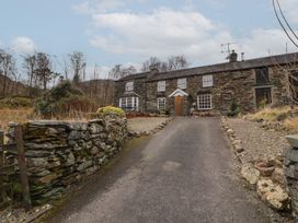 A stone house with windows and door at Deer How Farm Patterdale near Glenridding
