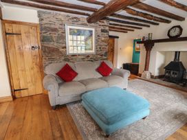 A living room with a sofa and fireplace at Deer How Farm in Patterdale near Glenridding