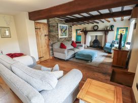 A living room with sofas and a fireplace at Deer How Farm in Patterdale near Glenridding