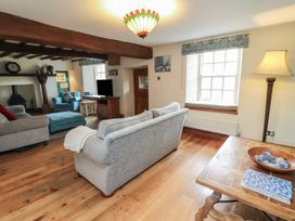 A living room with a sofa and armchair at Deer How Farm in Patterdale near Glenridding