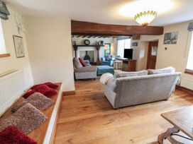 A living room with a sofa and armchair at Deer How Farm in Patterdale near Glenridding