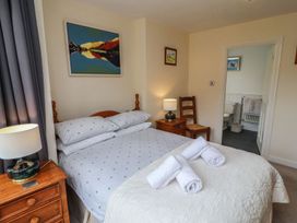 A bedroom with a bed and bedside table at Deer How Farm in Patterdale near Glenridding