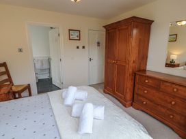 A bedroom with a bed and wooden furniture at Deer How Farm in Patterdale near Glenridding