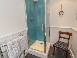 A bathroom with a shower and a chair at Deer How Farm in Patterdale near Glenridding