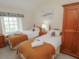 A bedroom with two beds and a wardrobe at Deer How Farm in Patterdale near Glenridding