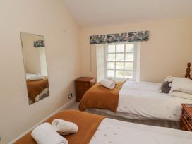 A bedroom with two beds and a mirror at Deer How Farm in Patterdale near Glenridding