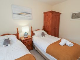 A bedroom with two beds and a wardrobe at Deer How Farm in Patterdale near Glenridding