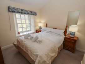 A bedroom with a bed and bedside lamps at Deer How Farm near Glenridding