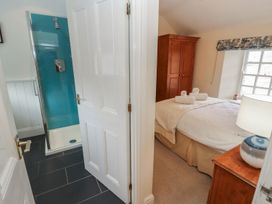 A bathroom with a shower and adjoining bedroom at Deer How Farm in Patterdale near Glenridding