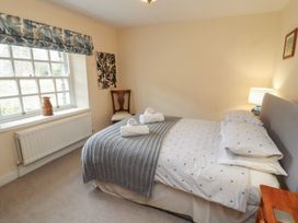 A bedroom with a bed and a window at Deer How Farm in Patterdale near Glenridding