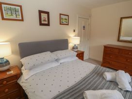 A bedroom with a bed and wooden furniture at Deer How Farm in Patterdale near Glenridding