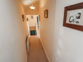 A hallway with framed artwork and a staircase at Deer How Farm in Patterdale near Glenridding