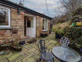 An outdoor seating area with a table and chairs at Deer How Farm in Patterdale near Glenridding